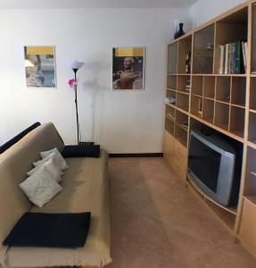 ein Wohnzimmer mit einem Sofa und einem TV in der Unterkunft Chianciano Lettings in Chianciano Terme