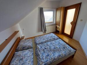 2 camas en una habitación pequeña con ventana en Apartman Daniela, en Jacovce