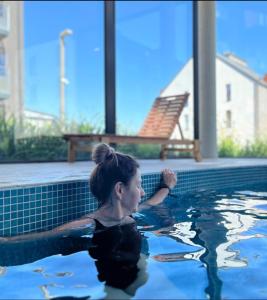 una mujer está en una piscina en Apartament Monte Ślęża & Spa, en Sobótka