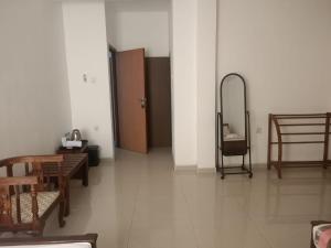 Zimmer mit einem Tisch, Stühlen und einem Spiegel in der Unterkunft Tenshin Residance. in Kandy