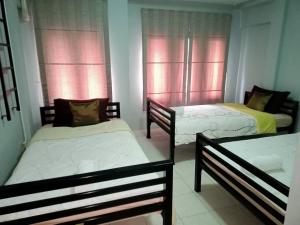 three beds in a room with pink windows at Fueangfu Home Hostel in Chaweng