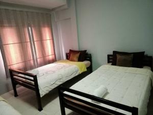 um quarto com 2 camas e uma janela em Fueangfu Home Hostel em Chaweng