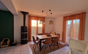 a dining room with a table and chairs and a stove at LAMELINE in Échenoz-la-Méline