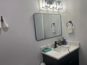 a bathroom with a sink and a mirror at Beautiful 2 Bedroom Guest Suite in Leduc 11 mins to Edmonton Intl Airport, Free Wifi, Netflix ,Cable & Workstation in Leduc