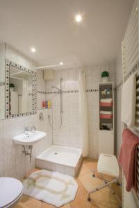 biała łazienka z umywalką i prysznicem w obiekcie Landhaus Alpenblick w Garmisch Partenkirchen
