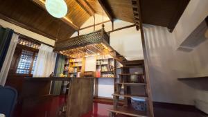 a room with a loft bed and a book shelf at Qingxin Courtyard Art Guesthouse in Dali