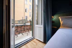 a bedroom with a bed and a view of a balcony at Fontana 16 Rooms in Milan