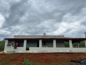 uma casa branca com um céu nublado por trás dela em Rancho São Francisco em São Roque de Minas