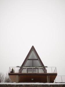 ein pyramidenförmiges Gebäude mit Schnee auf dem Boden in der Unterkunft Áčko in Oščadnica