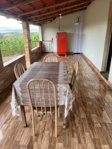 mesa de comedor con sillas y nevera en Rancho São Francisco en São Roque de Minas