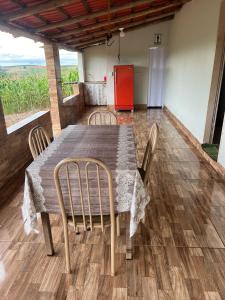 a dining room table with chairs and a refrigerator at Rancho São Francisco in São Roque de Minas