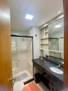 ein Bad mit einer Glasdusche und einem Waschbecken in der Unterkunft Makia Beach Resort Experience By All in Porto De Galinhas