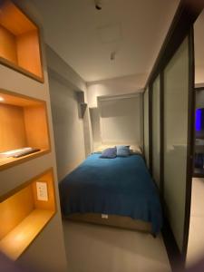 ein kleines Schlafzimmer mit einem blauen Bett in einem Zimmer in der Unterkunft Makia Beach Resort Experience By All in Porto De Galinhas
