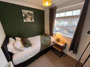 sypialnia z łóżkiem i zieloną ścianą w obiekcie Venture 1 - Comfortable & Convenient - PE2 w mieście Peterborough