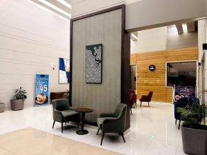 a lobby with chairs and a table in a building at Luxury Apartment Near Pari Chowk in Greater Noida