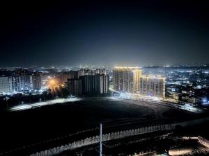 a view of a city at night with lights at Luxury Apartment Near Pari Chowk in Greater Noida
