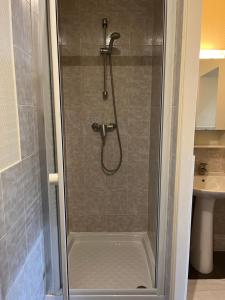 W łazience znajduje się prysznic ze szklanymi drzwiami. w obiekcie L’ESPERANCE w Wersalu