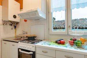 a kitchen with a stove and fruits and vegetables on a counter at Iseo Portelle Holiday with private parking in Iseo