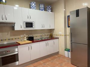 a kitchen with white cabinets and a stainless steel refrigerator at Casa Veva Tradición- Siles- in Siles