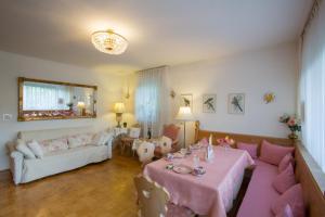 - un salon avec une table rose et un canapé dans l'établissement Landhaus Alpenblick, à Garmisch-Partenkirchen