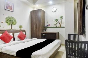 een slaapkamer met een groot bed met rode kussens bij Collection O 81293 Hotel Aditya Palace in Bhopal
