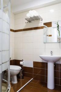 a bathroom with a toilet and a sink at Cozy apartment near Airport in Koropíon