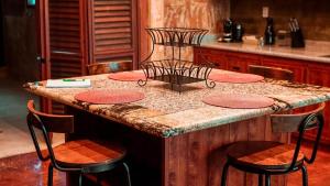 isla de cocina con 4 sillas y encimera en Hotel "ala Residencias", en Chetumal