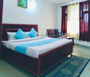 1 dormitorio con 1 cama grande con almohadas azules en Lake Cottage,Mcleodganj, en McLeod Ganj