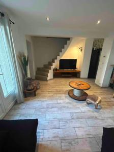 - un salon avec une table et un escalier dans l'établissement Belle maison proche du centre et des plages, à Montpellier