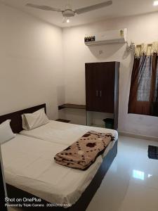 ein Schlafzimmer mit einem Bett mit einer Decke darauf in der Unterkunft Durga Pride in Kurnool