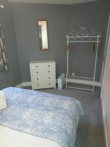 une chambre avec un lit, une commode et un miroir dans l'établissement 4B Wentworth Street Apartment, à Portree