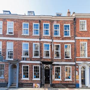 - un grand bâtiment en briques rouges avec des fenêtres blanches dans l'établissement Guy Fawkes Inn, à York