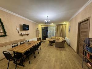 sala de estar con mesa, sillas y sofá en Villa Borjomi, en Borjomi