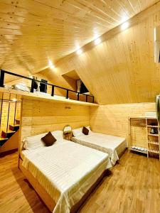 2 letti in una camera con soffitto in legno di PAL coffee & homestay a Vung Tau