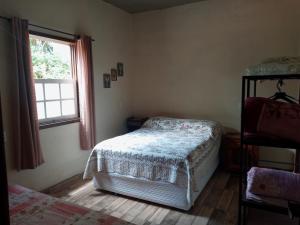 a bedroom with a bed and a window at Vila a Arte de Minas in Tiradentes