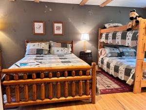 a bedroom with two beds and a bunk bed at Mountain Quest Inn in Marlinton