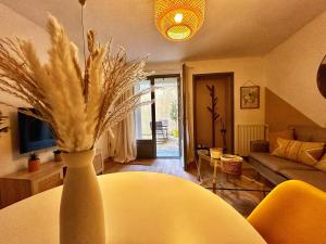una sala de estar con un jarrón con plumas. en Cosy Ocre, en Arles