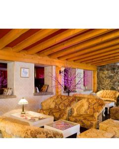 a living room with couches and tables at Chambre Hôtel Ibiza Spa - Hammam - Jacuzzis - Piscine Chauffée in Les Deux Alpes