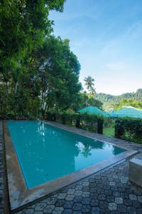 uma piscina num resort com árvores em Udapola Bungalow em Deraniyagala