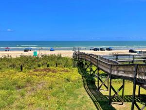 a view of a beach with cars in the background at The Aloha Beach in Surfside Beach