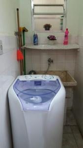 baño con bañera de color púrpura y blanco en Apartamento Aconchego da vovó, en Peruíbe 17 fotos más