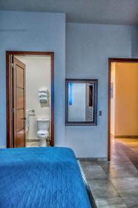 a bedroom with a bed and a toilet and a mirror at Casa Azul F2 in Puerto Peñasco