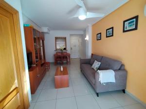 ein Wohnzimmer mit einer Couch und einem Tisch in der Unterkunft ACV - Vistamar II-1ª Linea Planta 9 Sur in Oropesa del Mar + 25 Fotos