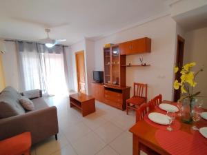 ein Wohnzimmer mit einer Couch und einem Tisch in der Unterkunft ACV - Vistamar II-1ª Linea Planta 9 Sur in Oropesa del Mar