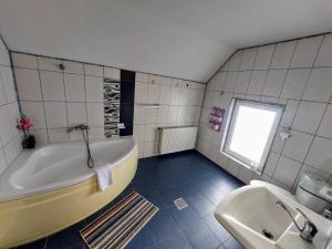 a bathroom with a tub and a sink at Paradisul Verde al Nathaliei in Cornu de Jos