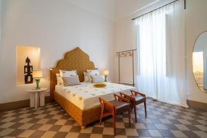 a bedroom with a large bed and a table and chairs at Palazzo Matteo in Nardò
