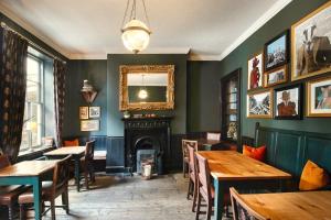 um restaurante com mesas de madeira e uma lareira em The Fat Badger York em York