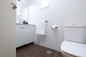 La salle de bains blanche est pourvue de toilettes et d'un lavabo. dans l'établissement Puerto Banús - Modern apartment 5 minutes from the beach, à Marbella