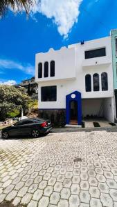 un coche negro estacionado frente a una casa blanca en Casa amplia con vista de altura en Toluca