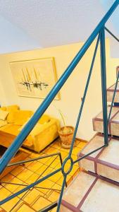 sala de estar con sofá amarillo y escaleras en Casa amplia con vista de altura en Toluca